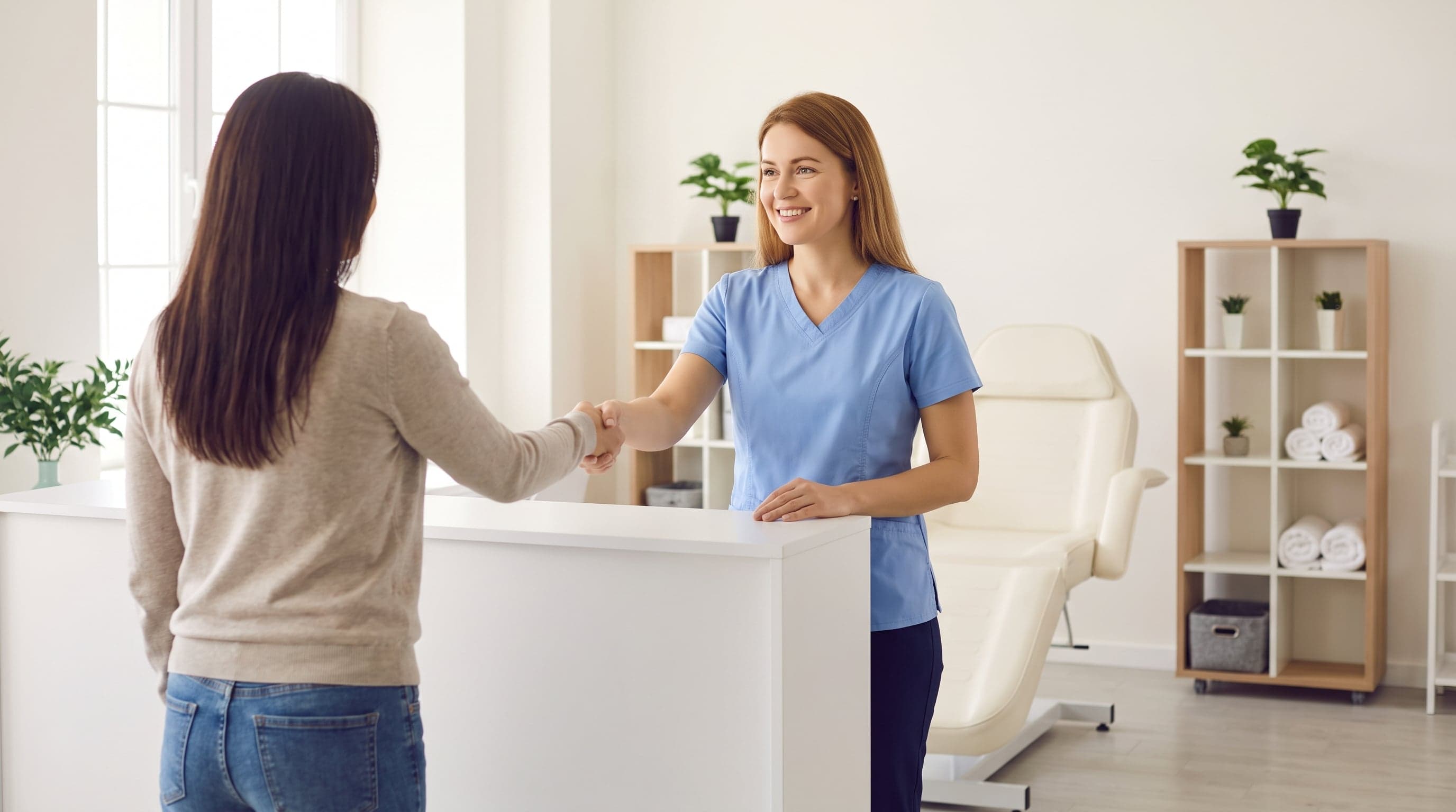 Med spa team greeting a client in a bright treatment room